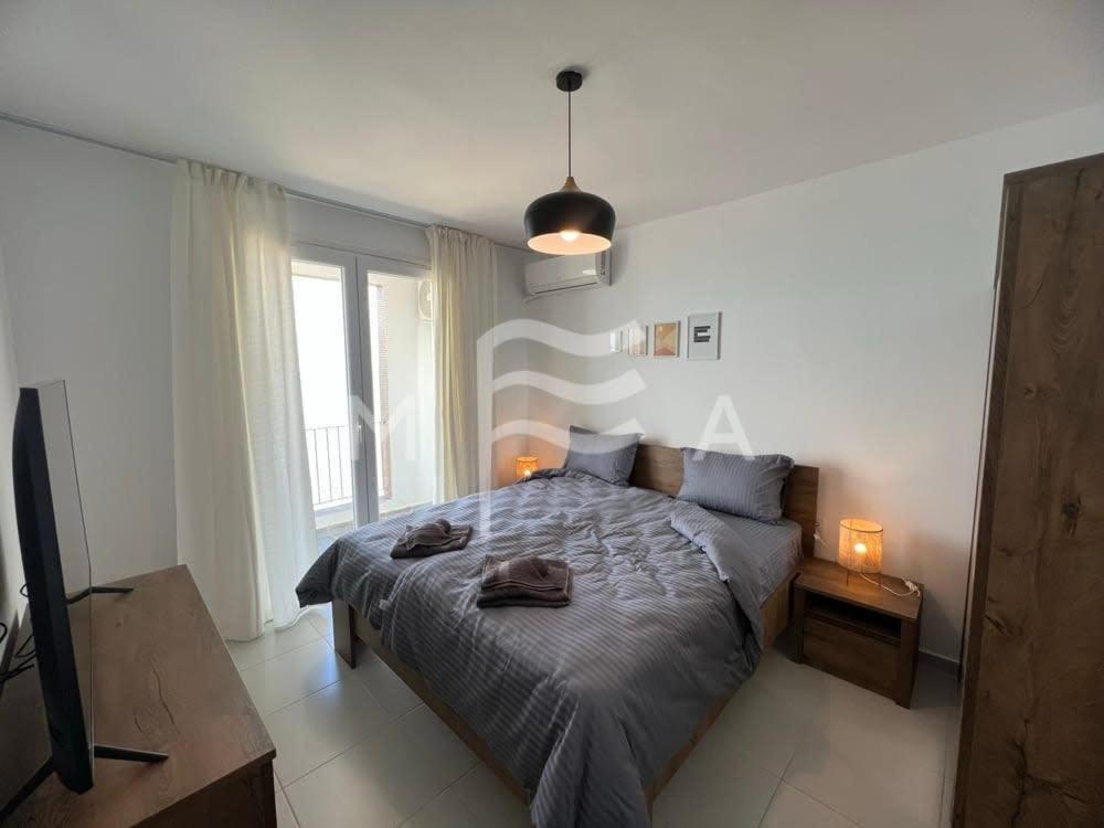 a bedroom with a bed and a large window at Essential 516 in Durrës