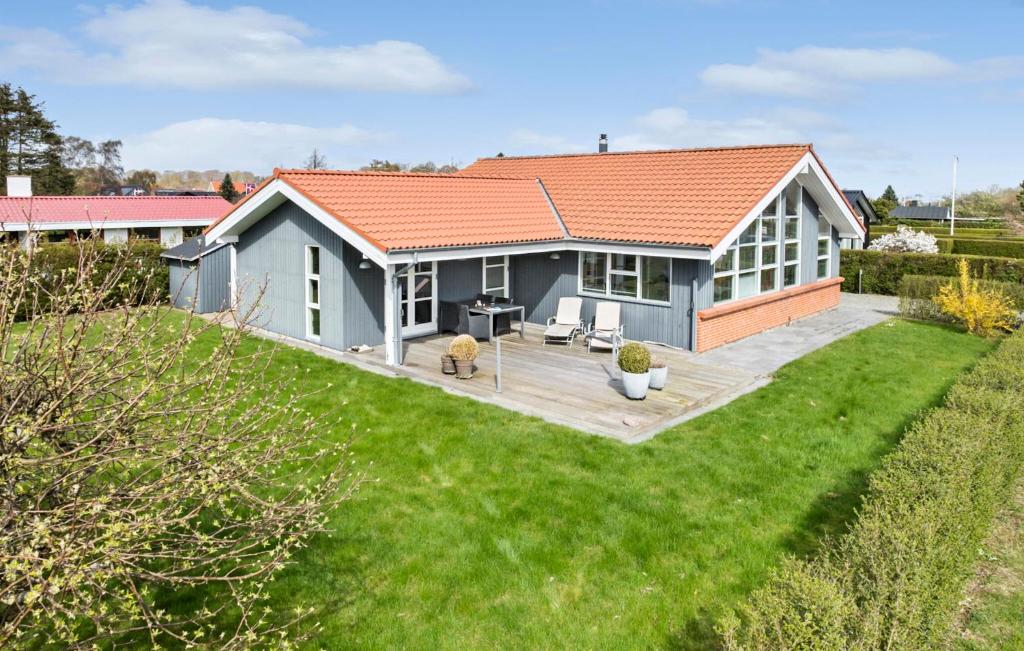 mały domek z trawnikiem przed nim w obiekcie Nice Home In Juelsminde With Kitchen w mieście Juelsminde