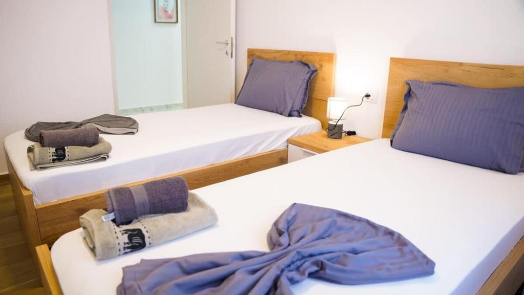 2 bedden in een kamer met paarse kussens bij Vacation 943 in Durrës