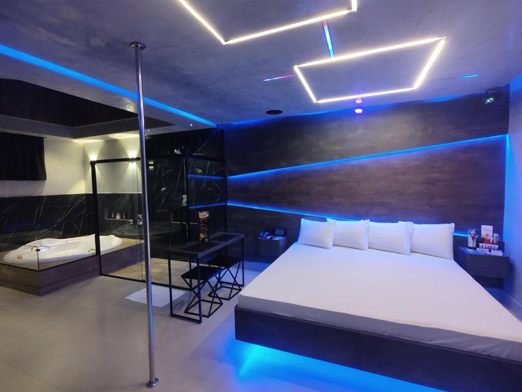 Schlafzimmer mit einem Bett und einer Glasdusche in der Unterkunft Prestige Motel 5 in Sorocaba