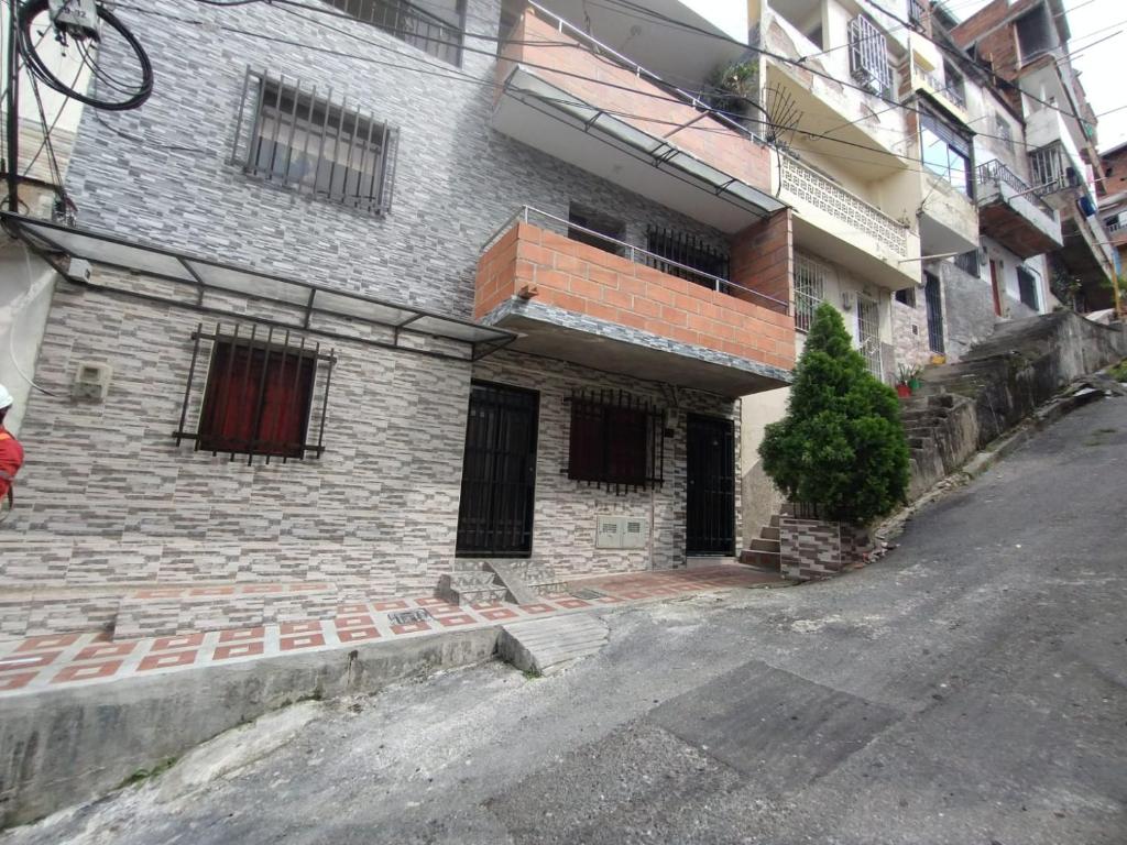 a brick building with a balcony on a street at Apartamento en el cerro la Asomadera in Medellín