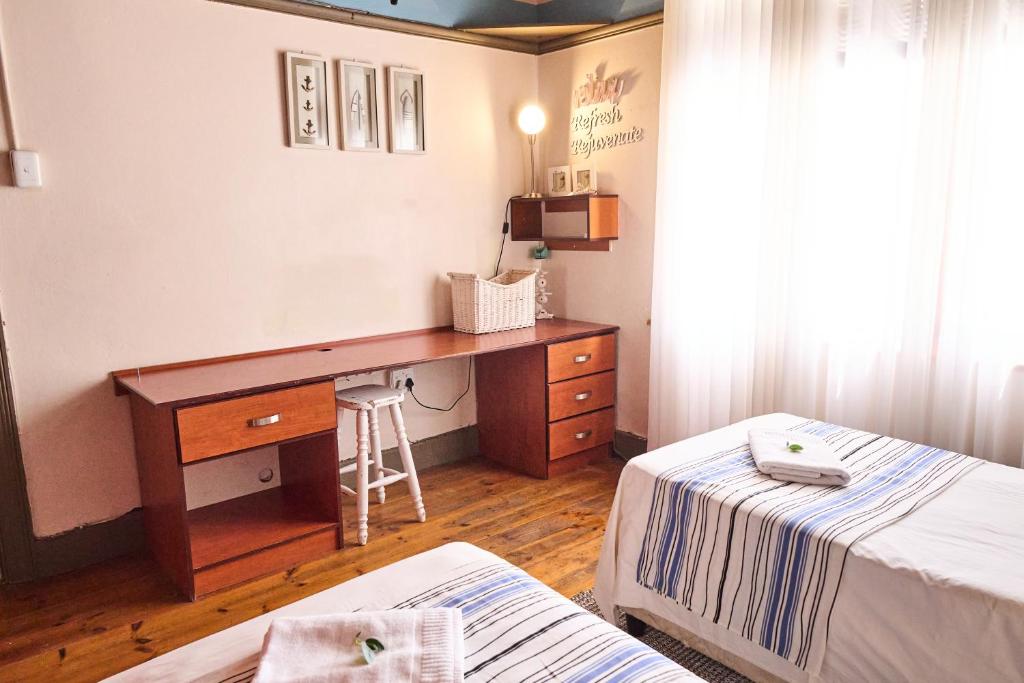 1 dormitorio con escritorio y 1 cama en Alakhe Self-Catering Accomodation Twin Bedroom, en Oudtshoorn