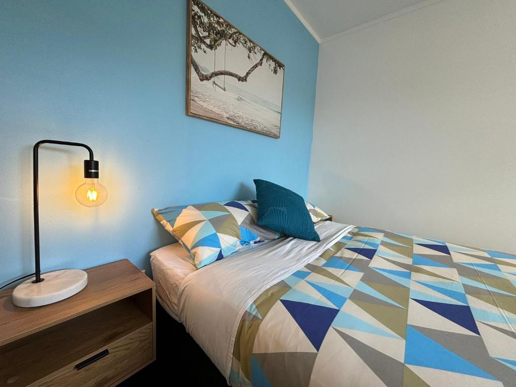 una camera da letto con un letto con una lampada sopra di Palm Tree Lodge a Paihia
