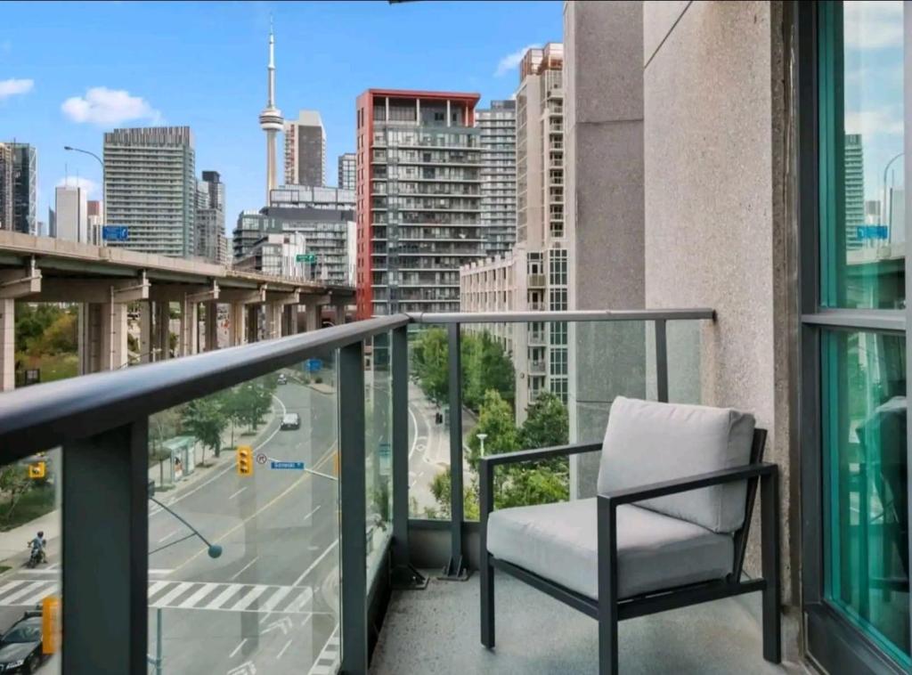a chair on a balcony with a view of a city at CN Tower View w/ Free Parking, Pool & Gym and More in Toronto