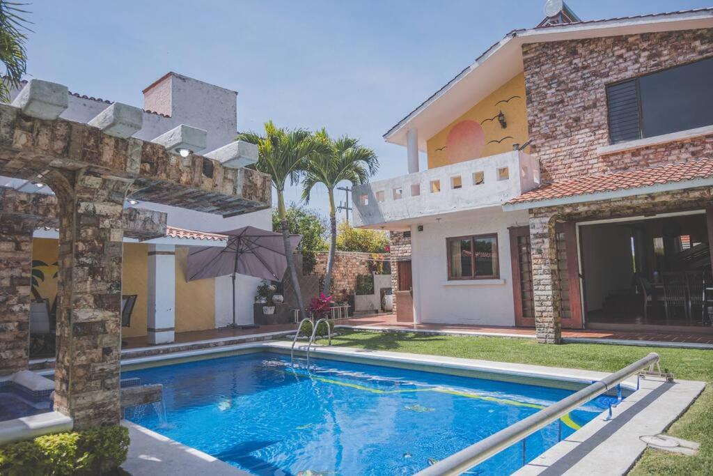 a swimming pool in front of a house at Casa Vacacional, Lomas Cocoyoc in Texcalpan