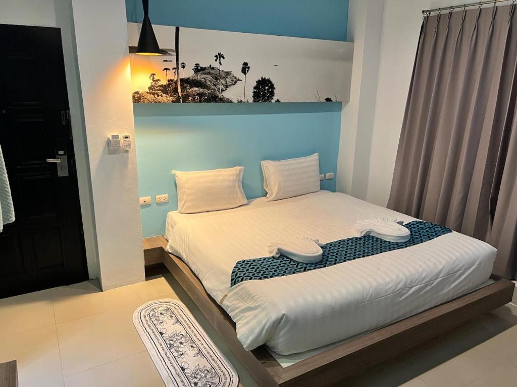 een kleine slaapkamer met een bed met witte lakens bij Hotel The Journey Patong New in Patong Beach