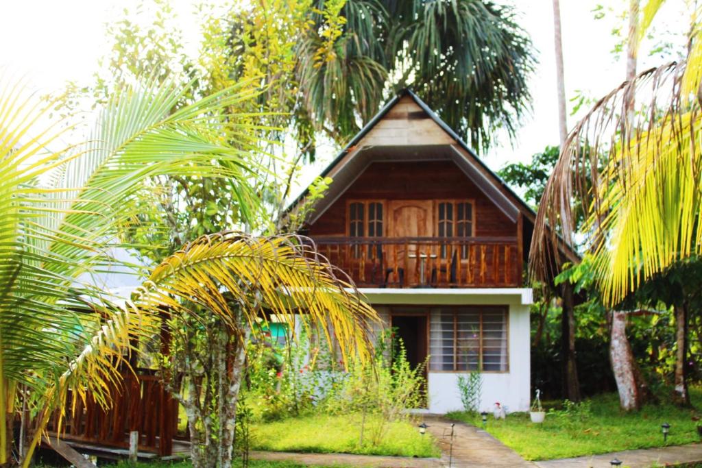 a house with a palm tree in front of it at Hipilandia International Hostel in Leticia