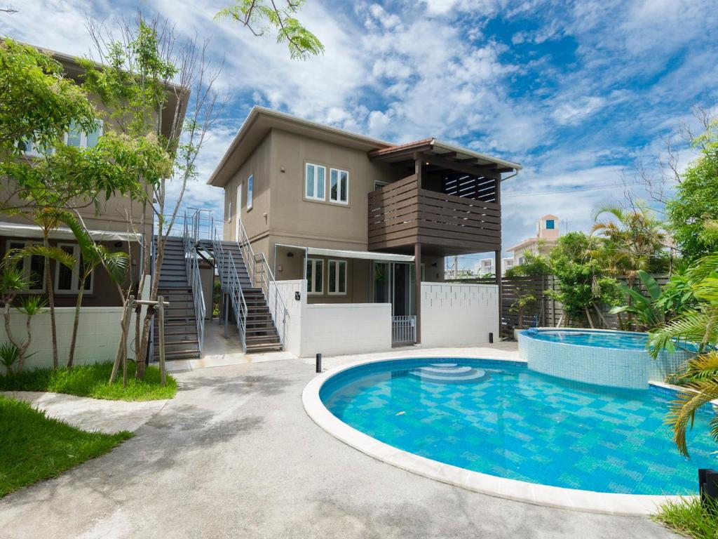 una imagen de una casa con piscina en Mihana恩納村, en Onna