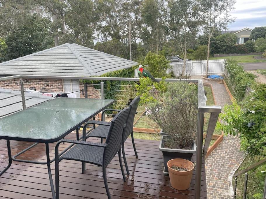 una terraza con mesa, sillas y sombrilla en Forests Edge, en Katoomba