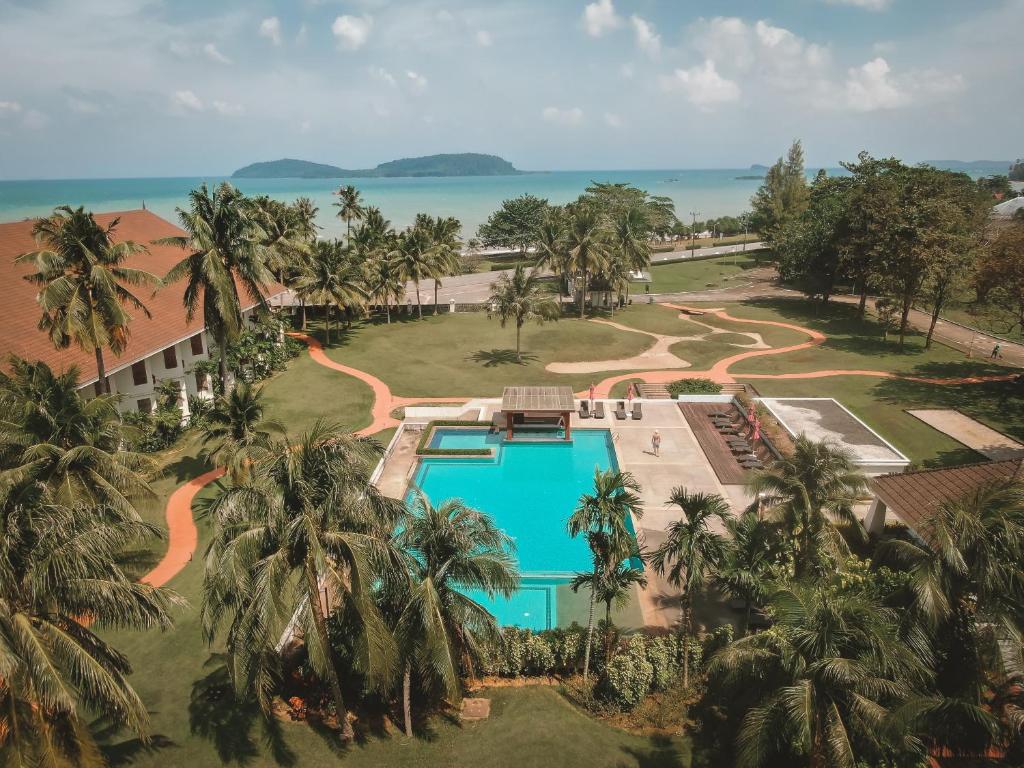 an aerial view of a resort with a pool and palm trees at The Nouveau Chumphon Beach Resort And Golf in Chumphon