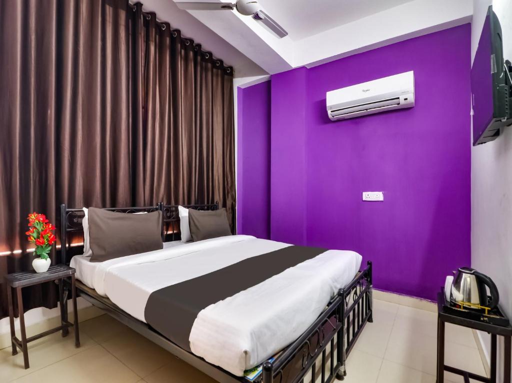 a bedroom with a purple wall and a bed at OYO Hotel Dev Palace in New Delhi