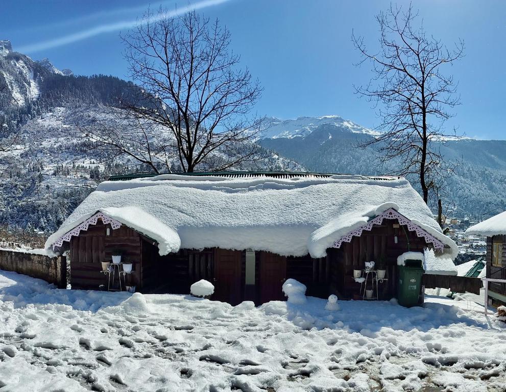 a cabin covered in snow with snow on the roof at Apple Valley Cottages Lachung in Lachung