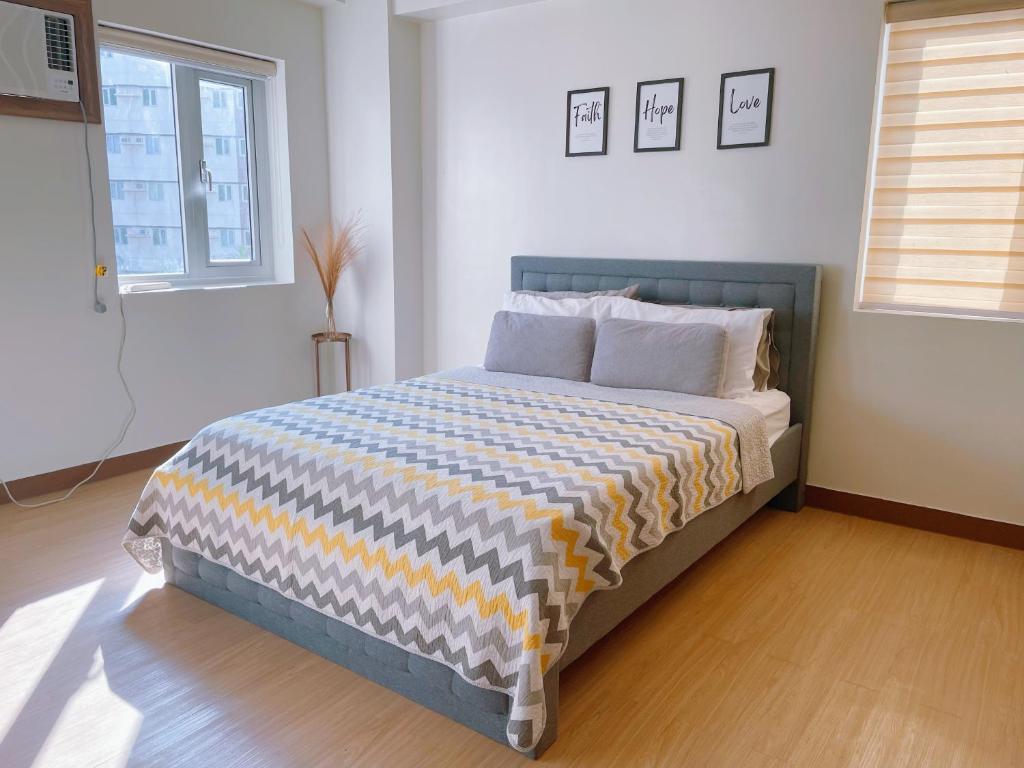 um quarto com uma cama com um cobertor azul e amarelo em Eco Suite em Trece Martires