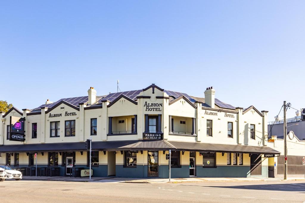 a large white building on the corner of a street at The Albion Hotel in Wickham
