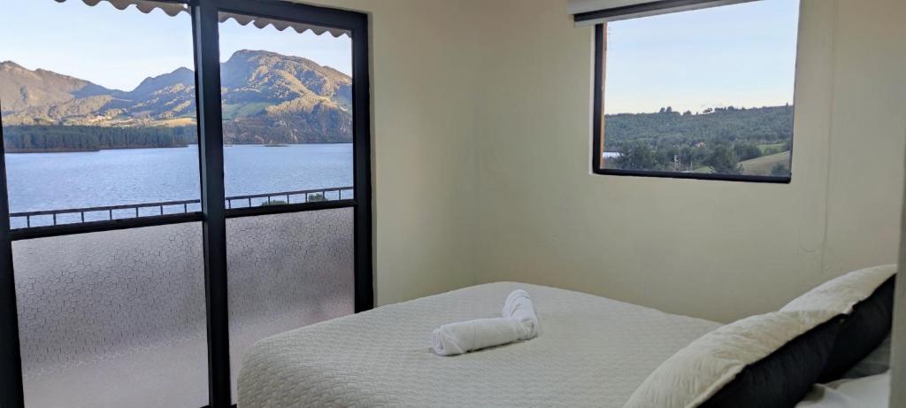 1 dormitorio con cama y vistas al lago en Neusa Mi Bello Amanecer, en Tausa Viejo