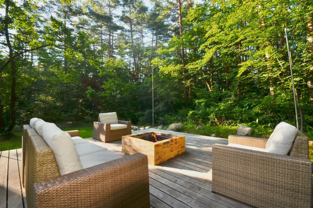 a patio with two couches and a fire pit at Muskoka House — Stunning architect-designed chalet in Hakuba