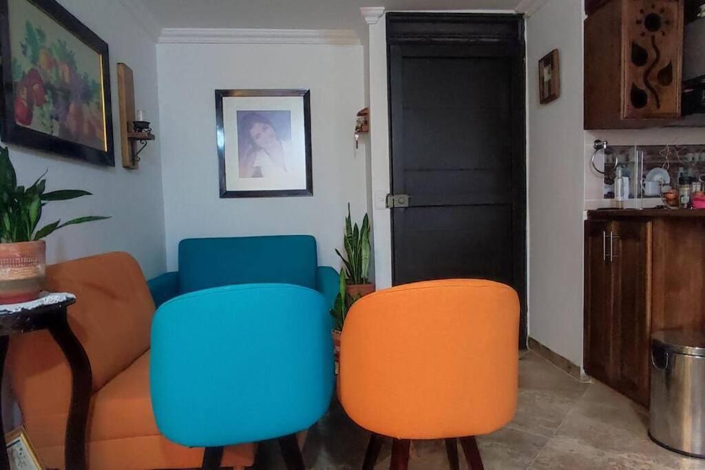 een woonkamer met 2 stoelen en een bank bij Hermoso apartamento en Girardota in Girardota