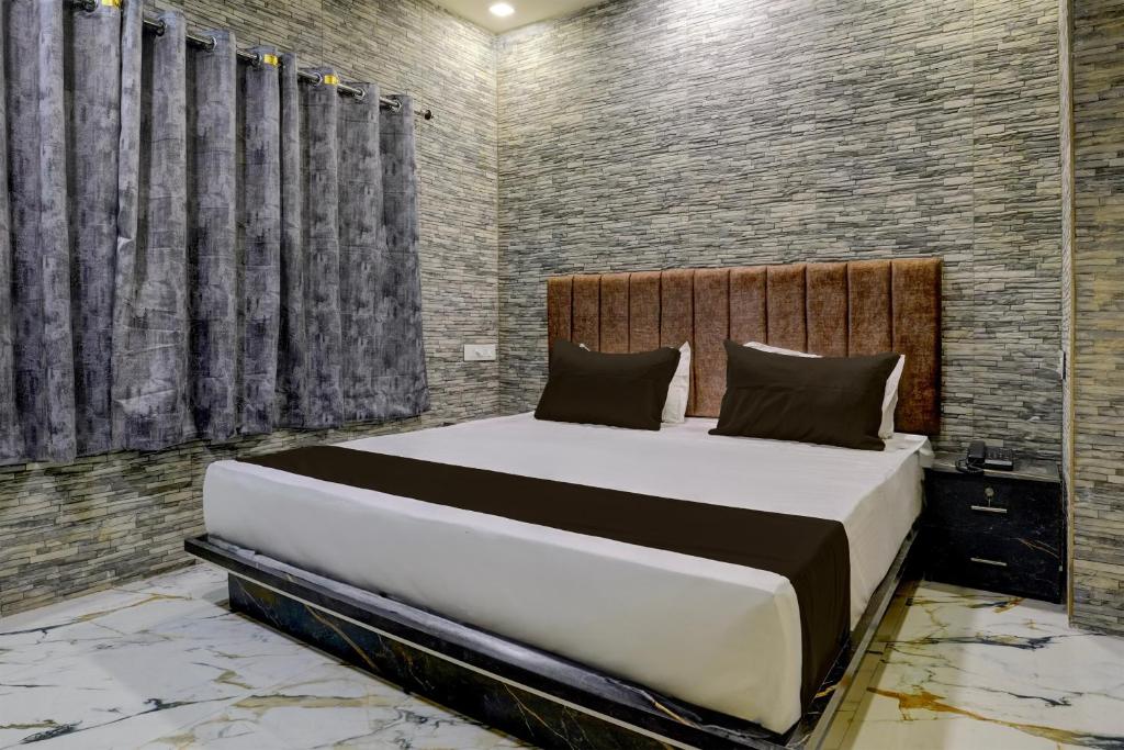 1 dormitorio con 1 cama grande en una habitación en Collection O Hotel Leo Inn, en Rajkot