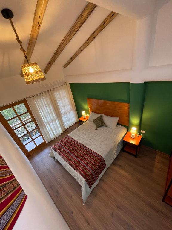 sypialnia z łóżkiem i zieloną ścianą w obiekcie Inca Allpa Home w mieście Huaran