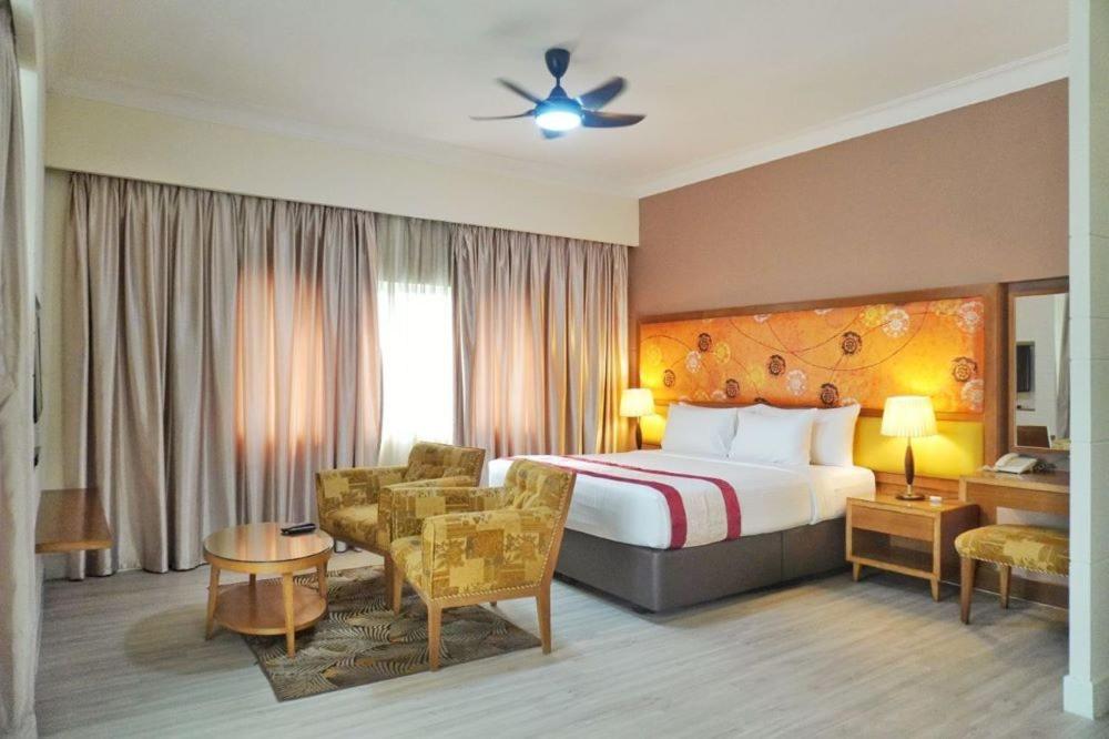 une chambre d'hôtel avec un lit et une chaise dans l'établissement The Avenue M, à Johor Bahru