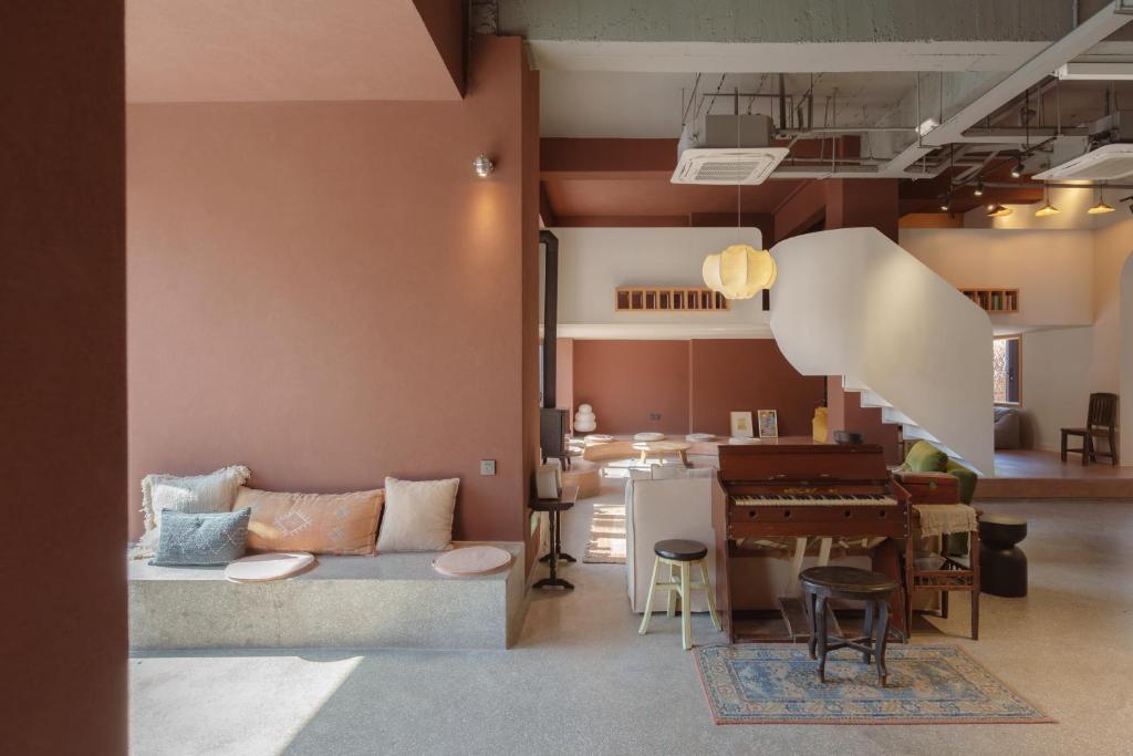 a living room with a couch and a piano at Mooke&Co Moganshan in Deqing