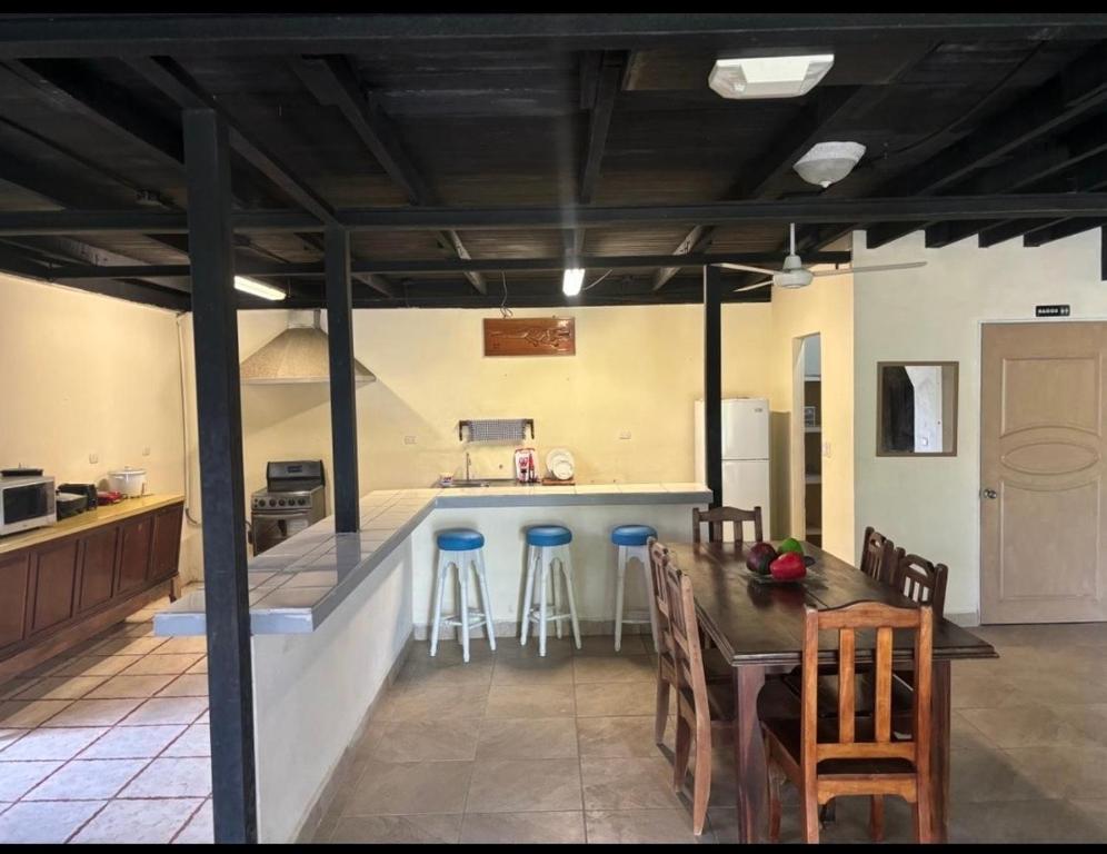 cocina y comedor con mesa y sillas en Casa la Picola, en Sierpe