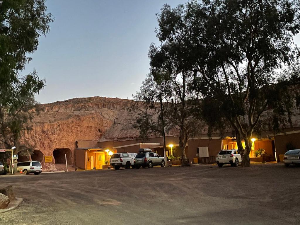 - un parking avec des voitures garées devant une montagne dans l'établissement Desert View Apartments, à Coober Pedy