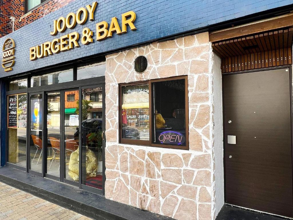 a store front of a burger and bar on a street at ゲストハウス JOOOY Hotel 奄美 in Amami