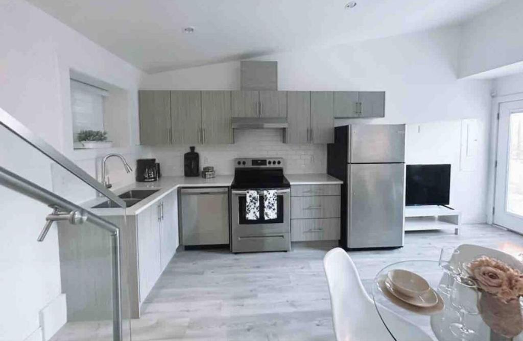 a kitchen with stainless steel appliances and a table at Modern Home in Vancouver close to Downtown and Airport in Vancouver