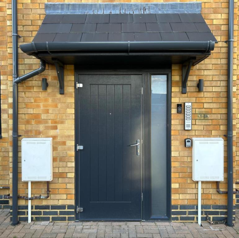 a black door on the side of a brick building at Southborough Suite in Kent