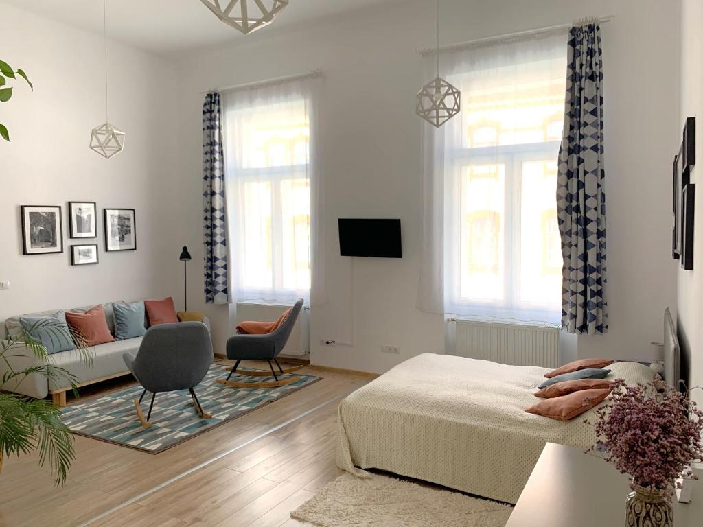 - un salon avec un lit et un canapé dans l'établissement Charming Central Apartments, à Cluj-Napoca