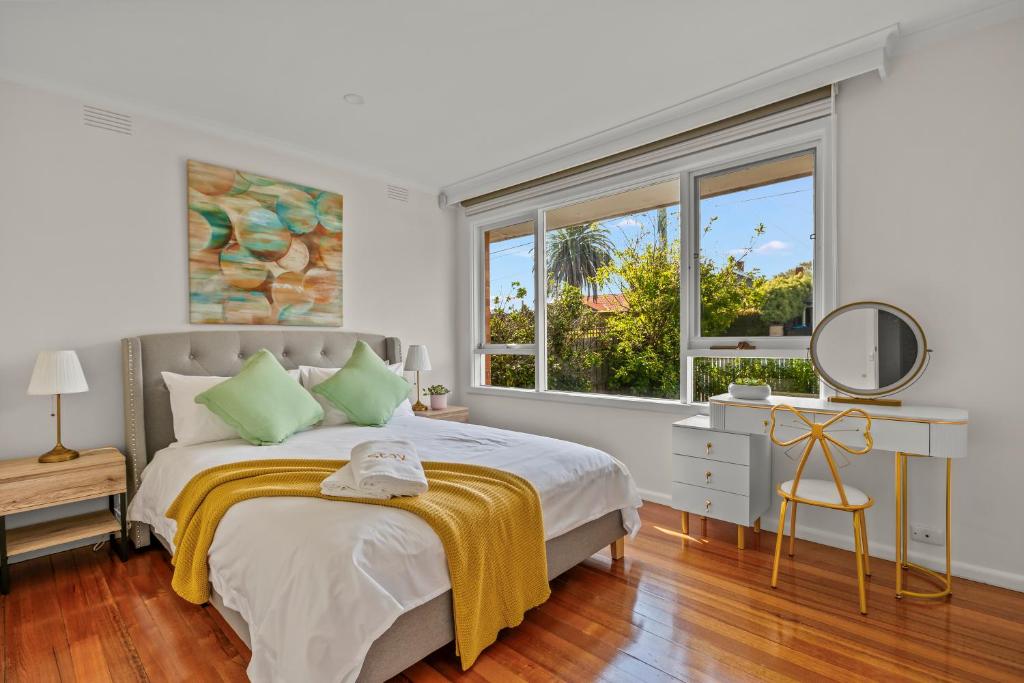 a white bedroom with a bed and a window at StayAU 2BRM Beach Family House Hampton in Melbourne