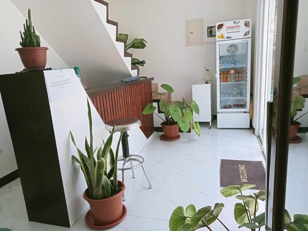 a room with potted plants and a refrigerator at KMJ SUITES in General Luna