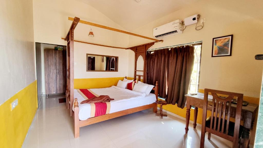 a bedroom with a bed and a desk in it at The SKYi County Dapoli in Dapoli