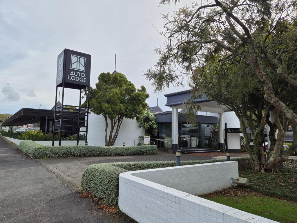 un edificio con una señal delante de él en Auto Lodge en New Plymouth