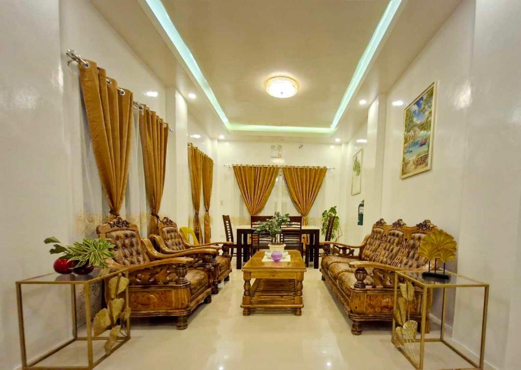 a living room with couches and a table at Drossgold Pension House in Tubigon