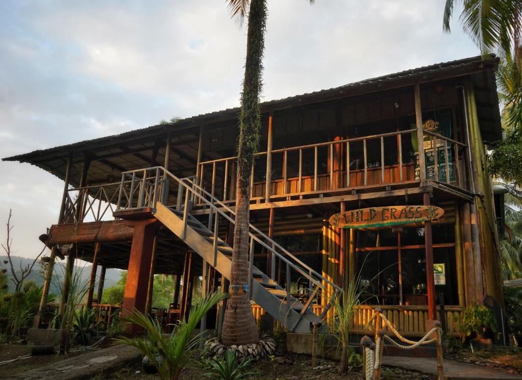 un gran edificio de madera con balcón y una palmera en Wild Grass Resort en Port Blair