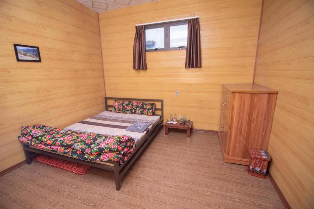 Habitación pequeña con cama y ventana en Mộc Mây Homestay, en Ha Giang