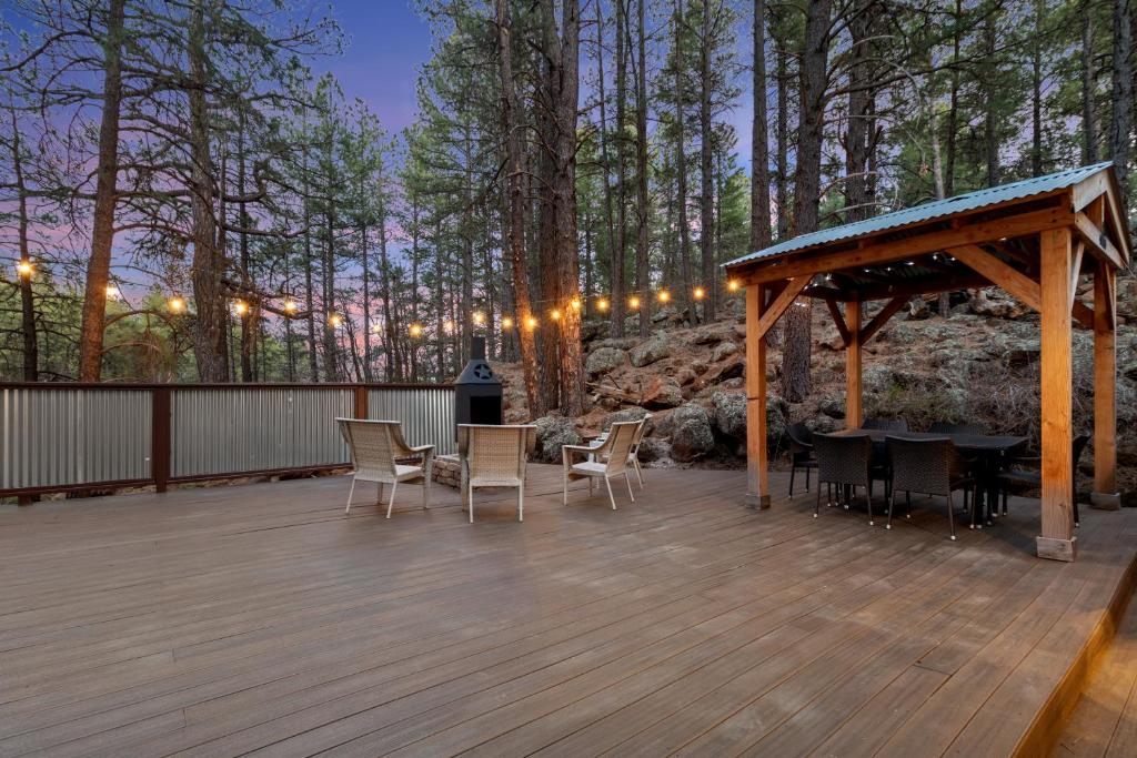 eine Holzterrasse mit Stühlen, einem Tisch und einem Pavillon in der Unterkunft The Cozy Cottage in Flagstaff
