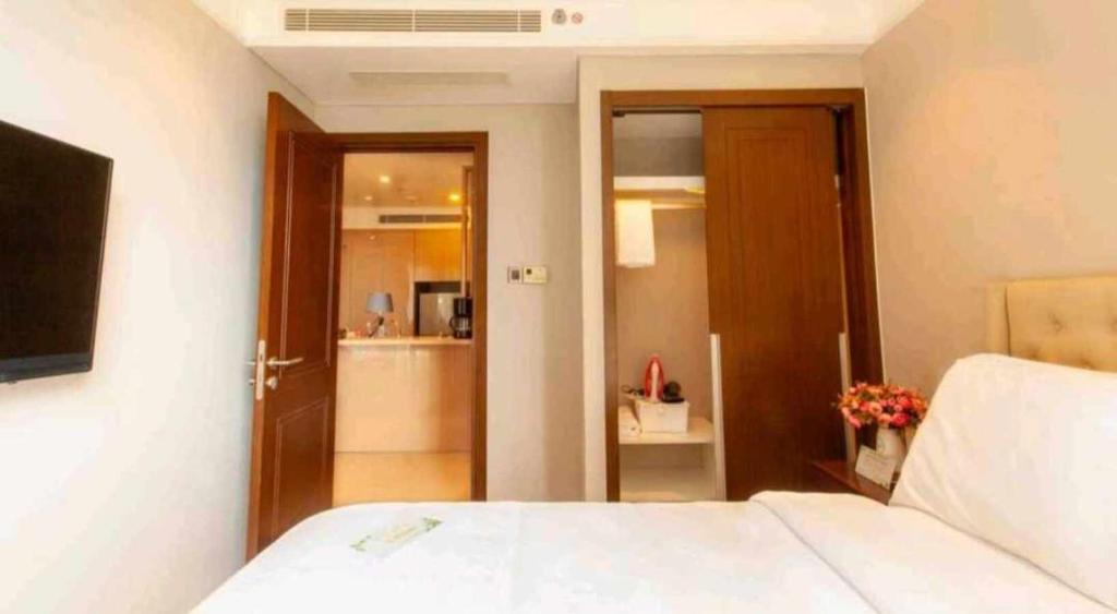 a bedroom with a white bed and a bathroom at Apartment with Ocean view in Danang