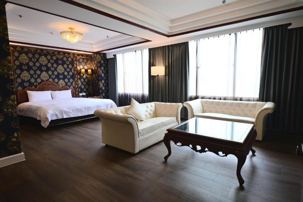 a hotel room with a bed and a couch and a table at T Hotel in Taichung