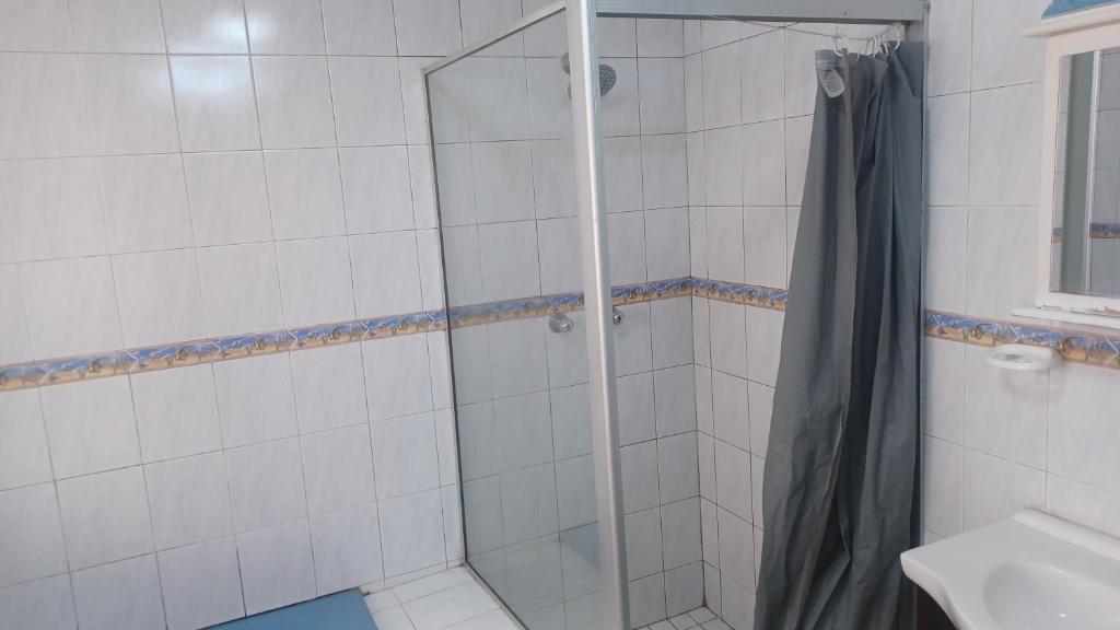 a shower with a glass door in a bathroom at De'moore Guest House in Johannesburg