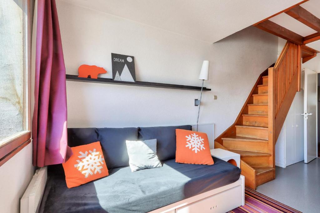 - un salon avec un canapé bleu et des oreillers orange dans l'établissement Résidence Quartier Falaise - maeva Home - Appartement 2 pièces 7 personnes 844, à Avoriaz