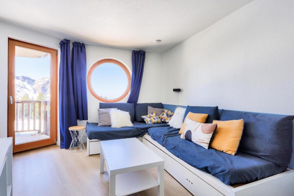 a living room with a blue couch and a window at Résidence Quartier Falaise - maeva Home - Appartement 2 pièces 7 personnes 454 in Avoriaz