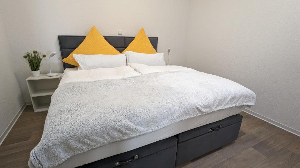 a bedroom with a bed with white and yellow pillows at Ferienwohnung Urban -Ekhof- in Gotha