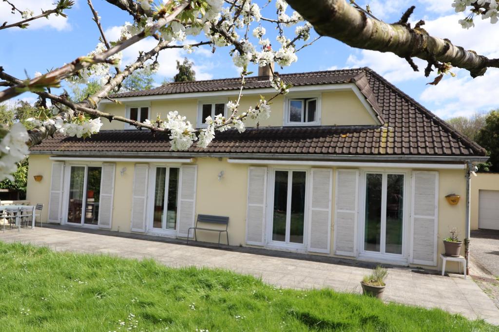 ein Haus mit weißen Türen und Fenstern in der Unterkunft M&A maison de campagne/ Disney/Paris/Wifi/Jeux in Croissy-Beaubourg