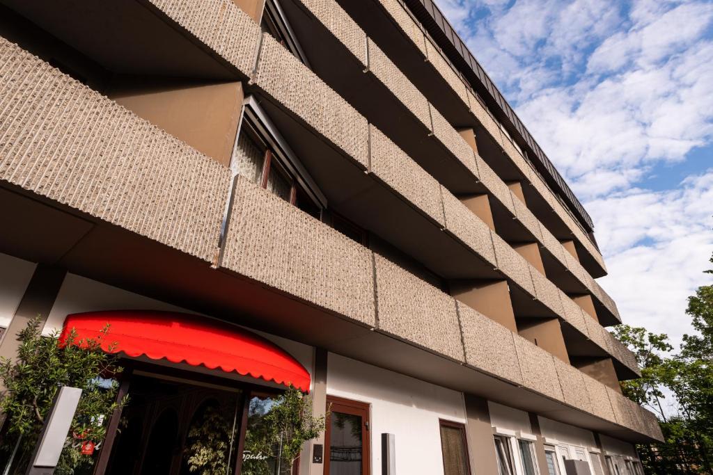 eine Fassade eines Gebäudes mit roter Markise in der Unterkunft Hotel Spahr in Stuttgart