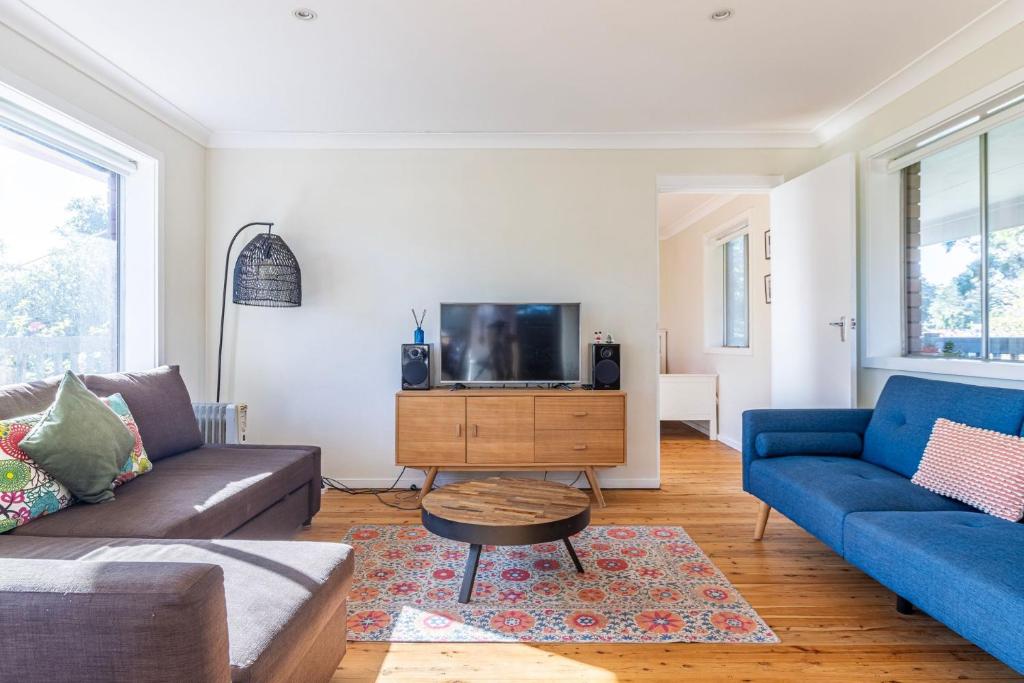 ein Wohnzimmer mit einem Sofa und einem TV in der Unterkunft Yarroma in Berrara