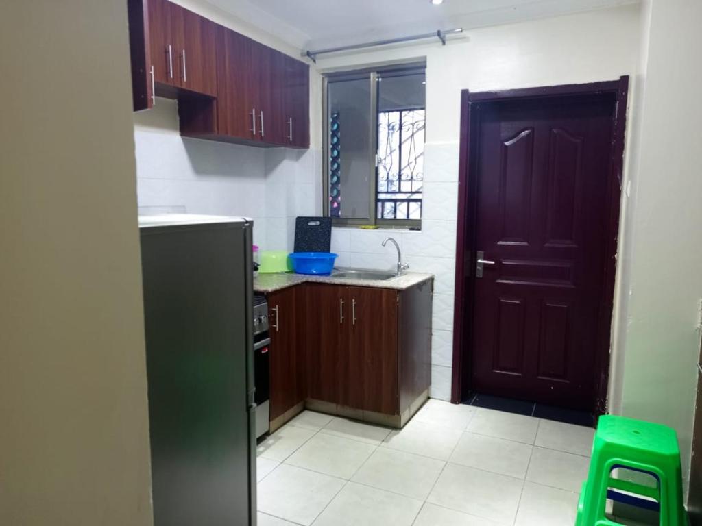 a kitchen with a black refrigerator and a black door at Atalia Athi River in Nairobi