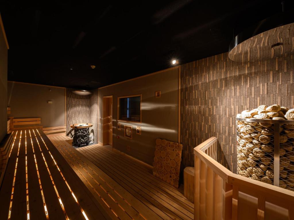 a room with a wooden floor and a wall with logs at The Centurion Sauna Rest & Stay Sapporo Male Only in Sapporo